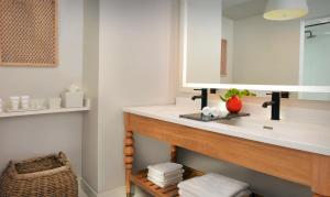 a bathroom with a sink and a mirror at Pelican Grand Beach Resort, a Noble House Resort in Fort Lauderdale