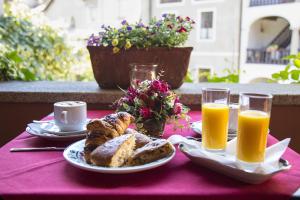 een tafel met brood en twee glazen sinaasappelsap bij B&B Locanda Tempi Lontani Adults Only in Orta San Giulio