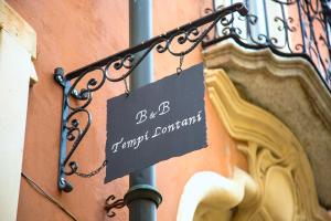 a sign hanging on a pole next to a building at B&B Locanda Tempi Lontani Adults Only in Orta San Giulio