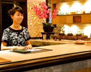 a woman sitting at a counter in a restaurant at Hanamitsu Hotel & Spa in Garapan