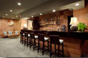 a bar with a row of chairs in a room at Hanamitsu Hotel & Spa in Garapan