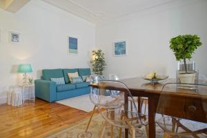 ein Wohnzimmer mit einem Tisch und einem blauen Sofa in der Unterkunft Lisbon City Center in Lissabon