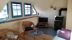 un soggiorno con tavolo, sedie e TV di Landhaus Maltzien auf Rügen a Maltzien