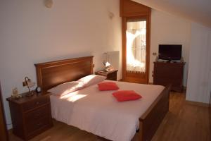 a bedroom with a bed with two orange pillows on it at Villa Serena in Aosta
