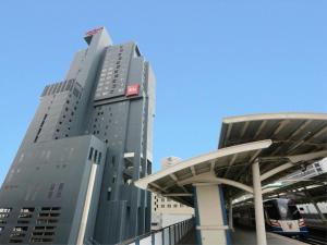 a tall gray building with a red sign on it at ibis Bangkok Siam in Bangkok