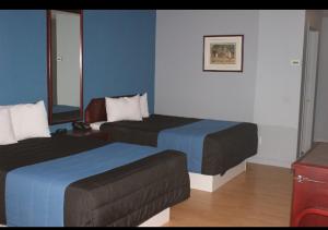 une chambre d'hôtel avec deux lits et un canapé dans l'établissement Motel Le Victo, à Victoriaville