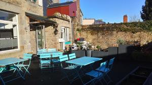 a group of blue tables and chairs outside a building at H&ocirc;tel Patton in Avranches