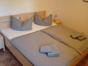 uma cama com duas almofadas e duas toalhas em Godewind em Insel Poel