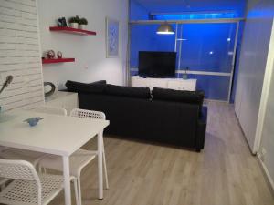 salon z czarną kanapą i stołem w obiekcie Moderno apartamento Torremolinos centro w mieście Torremolinos