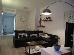 salon z czarną kanapą i zegarem w obiekcie Moderno apartamento Torremolinos centro w mieście Torremolinos
