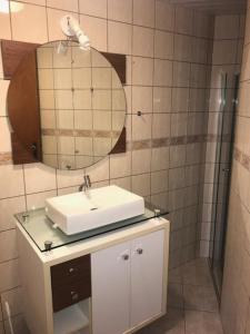 a bathroom with a sink and a mirror at Vista para o Mar a 180 m da Praia in Meia Praia +9 photos