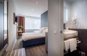een hotelkamer met een bed en een wastafel bij Joy Hotel in Amsterdam