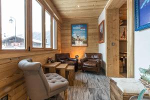 un salon avec des chaises, une table et des fenêtres dans l'établissement Chalet Yolo - Chalet Retreat in Central Chamonix Steam Room, à Chamonix-Mont-Blanc