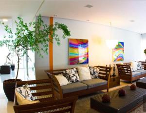 a living room with a couch and paintings on the wall at Hotel Veredas do Rio-quente/ Particular in Rio Quente