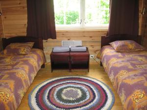 a room with two beds and a rug on the floor at Männi Farm Holiday House in Eoste