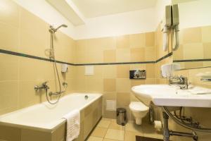 a bathroom with a sink, toilet and bathtub at Grand SPA Lietuva Hotel Druskininkai in Druskininkai
