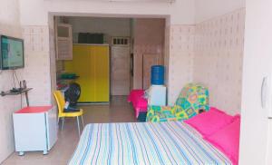 a room with a bed and colorful chairs in it at Kitnet Mobiliada in São Luís