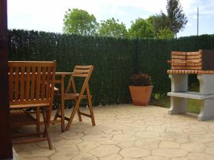 een patio met 2 stoelen, een tafel en een hek bij La Pergola in Santillana del Mar