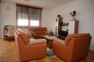 ein Wohnzimmer mit 2 Stühlen und einem TV in der Unterkunft Apartmani MARIN in Županja