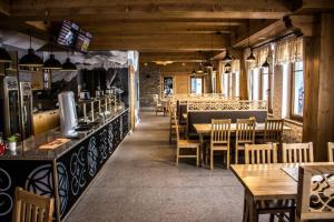 a restaurant with tables and chairs and a bar at Karcma Hajnos Pokoje in Białka Tatrzańska