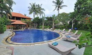 勒吉安Three Brothers Bungalows & Villas的房子旁边有带躺椅的游泳池