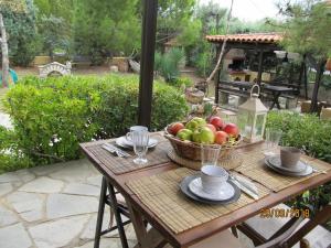 a wooden table with a basket of fruit on it at House Antaya in Nikiti