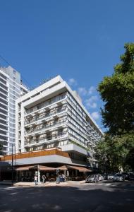 un gran edificio blanco con coches estacionados frente a él en Palermo Soho Square en Buenos Aires