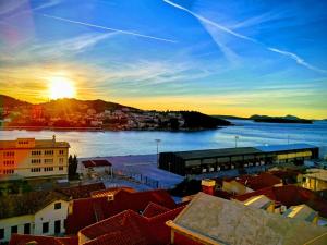 a sunset over a city with a river and buildings at Nostromo Guesthouse with the Sea View in Dubrovnik