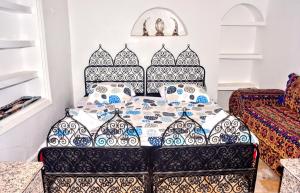 a bedroom with a bed with blue and white pillows at Riad Razoli Sidi Daoui in Rabat