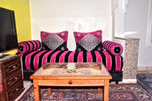 a living room with a couch with pillows and a coffee table at Riad Razoli Sidi Daoui in Rabat