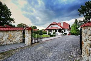 a house with a gate and a stone wall at Willa Kazimiera in Kazimierz Dolny