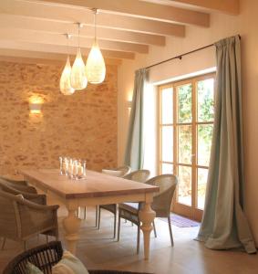 a dining room with a wooden table and chairs at Living Casa Luna in Santanyi