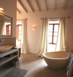 een badkamer met 2 wastafels en een groot bad bij Living Casa Luna in Santanyi
