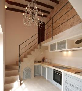 een trap in een keuken met een kroonluchter bij Living Casa Luna in Santanyi