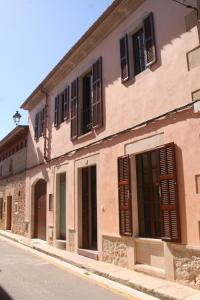 a building with windows and shutters on a street at Living Casa Luna in Santanyi
