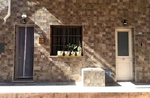 un edificio in mattoni con una finestra con piante in vaso di Casa Garito Teresa a Lampedusa