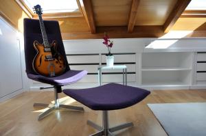 una guitarra sentada en una silla junto a una mesa en Catedral Site by Como en Casa, en Santiago de Compostela