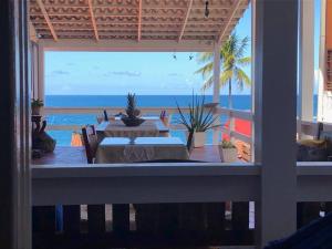 un patio con mesa y vistas al océano en Pousada Via Brasil, en Morro de São Paulo