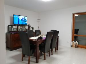 a dining room table with black chairs and a flat screen tv at Liliowa in Godziszka