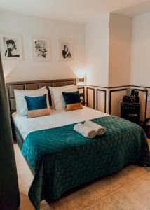 a bedroom with a large bed with blue pillows at The Harlemstreet Suites in Amsterdam