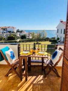 een tafel en stoelen op een balkon met uitzicht op de oceaan bij Cala Balmins Sea View in Sitges