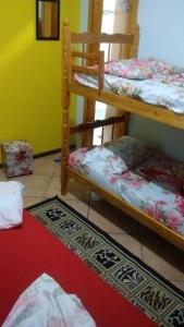 a room with two bunk beds and a red carpet at POUSADA FAMILIAR S.R. in São Gabriel