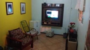 sala de estar con TV de pantalla plana y sillas en POUSADA FAMILIAR S.R., en São Gabriel