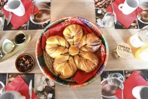 un tavolo con un cesto di pane sopra di Chambres d'hôtes entre Arras et Albert - Bed and Breakfast a Souastre