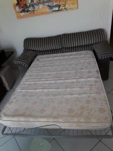 una cama sentada en una habitación junto a un sofá en Res Calliandra Apto 103, en Bombinhas