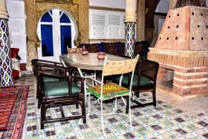 a dining room with a table and chairs and a fireplace at Riad Razoli Sidi Daoui in Rabat