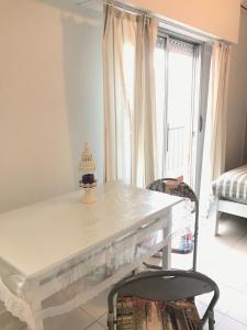 una mesa y sillas blancas en una habitación con ventana en Apartamentos Paraguay Soleado Excelente Ubicacion en Buenos Aires