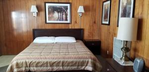 A bed or beds in a room at The Whispering Elms Motel