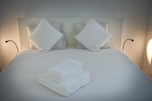 a white bed with pillows and towels on it at Davcom Studio in Făgăraş