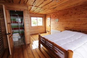 a bedroom with a bed in a wooden cabin at Hotel Mitos in Quellón
